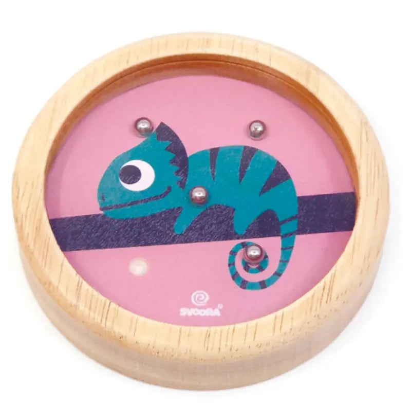 The Wooden Balance Game Chameleon is a round wooden handheld toy with a blue chameleon design and small metal balls, set against a pink background—ideal for on-the-go play and travel fun.