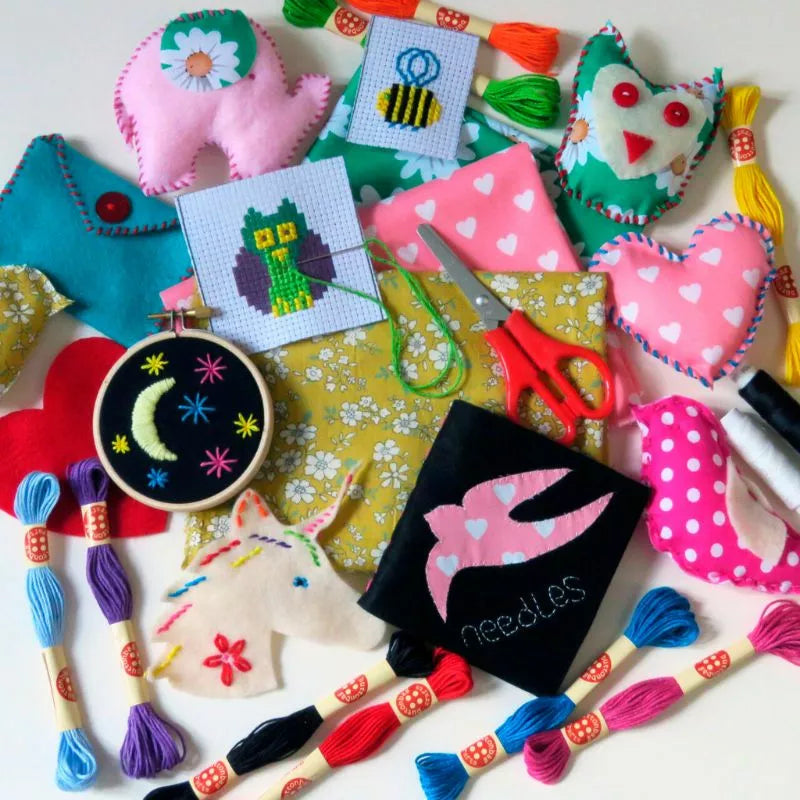 A variety of Buttonbag Bumper Sewing and Embroidery Bumper Kits are laid out on a table.