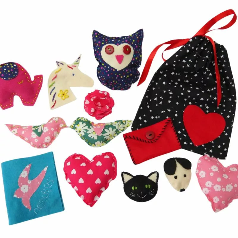 A Buttonbag Learn to Sew Suitcase Kit filled with a variety of felt animals, hearts, and owls.