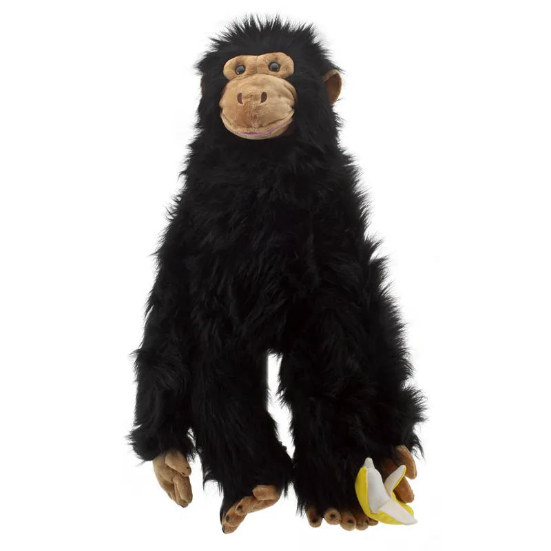 Product Description: The Puppet Company Large Puppet Chimp, a plush hand puppet featuring long black fur and designed to hold a small fabric banana, displayed against a plain white background.
