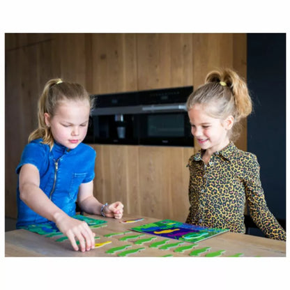 Two young girls playing Buitenspeel Parrots Collection Game on a table.