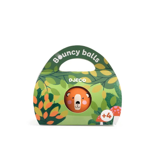 A colorful packaging for Djeco Skill Game Bouncing Ball - Wild Bear made of natural rubber, with a large clear window displaying one visible ball with a cartoon bear face. The box is green with leaf and berry designs and includes a