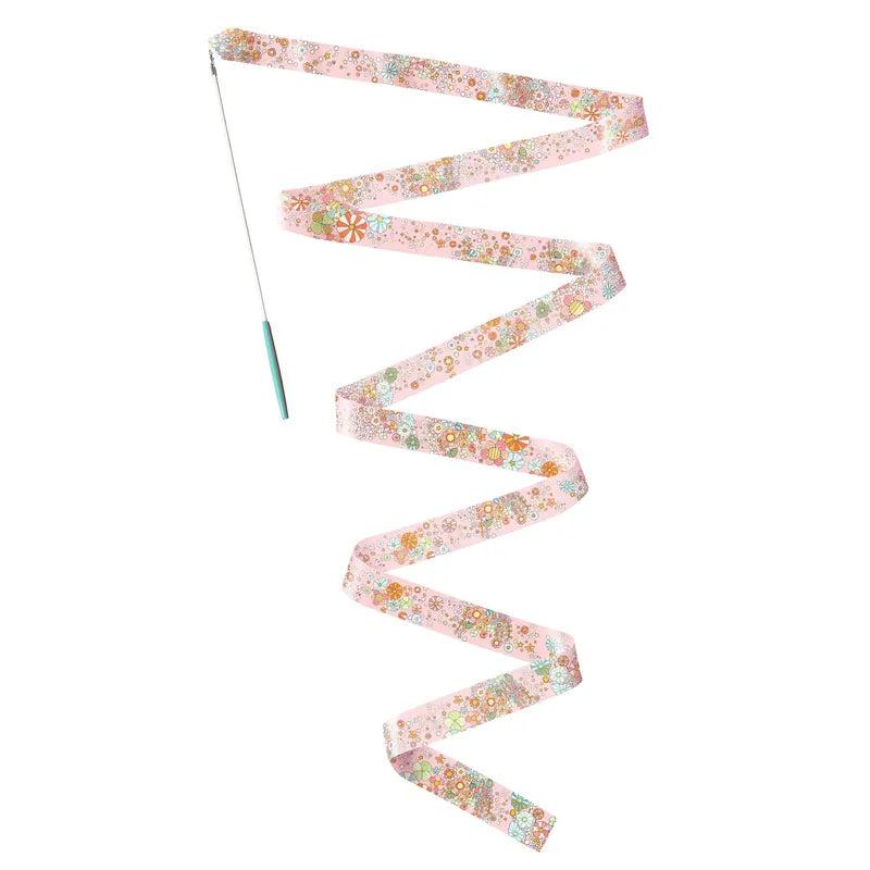 A hand-held Djeco Gymnastic Ribbon Stella with a long, pink ribbon adorned with small floral patterns spiraling elegantly in mid-air, isolated on a white background.