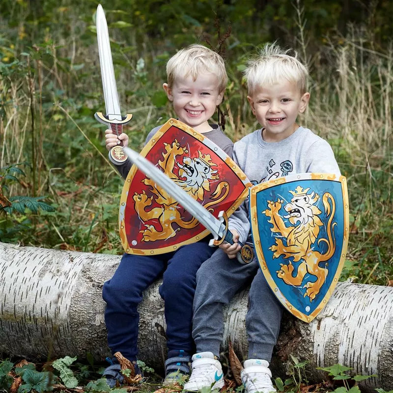 two boys with the Liontouch Noble Knight Set for 2 sitting on a log in the woods.