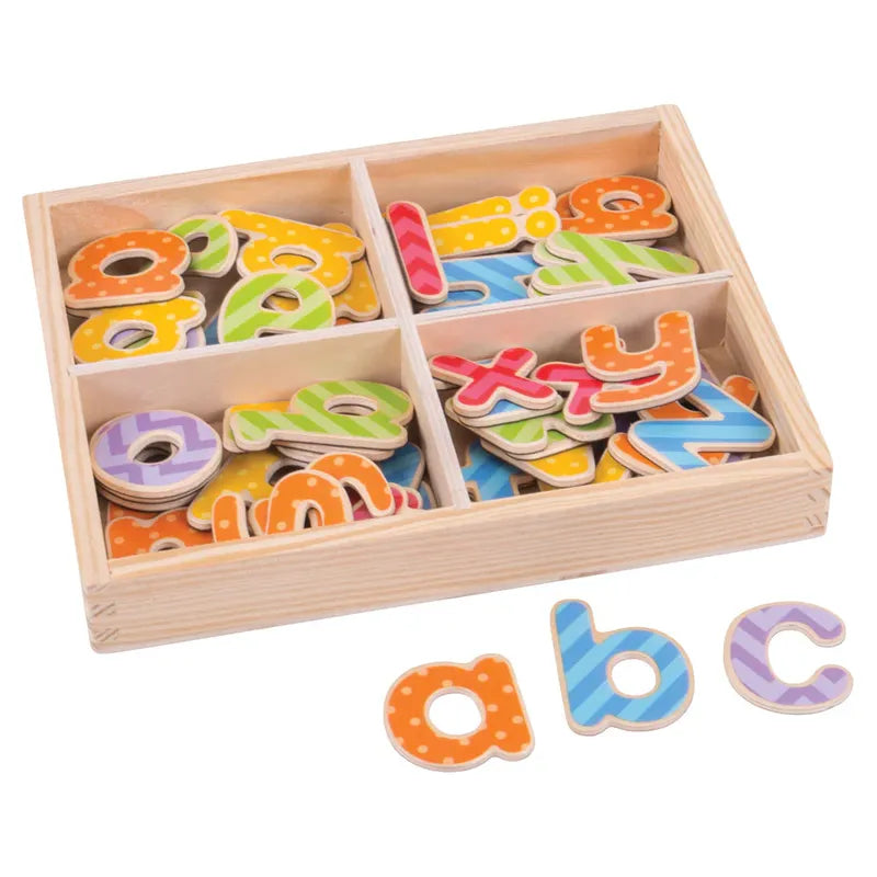 A wooden box containing four compartments is filled with colorful, patterned Bigjigs Magnetic Letters (Lowercase), designed with polka dots and stripes. Three lowercase letters, "a," "b," and "c," sit outside the box.