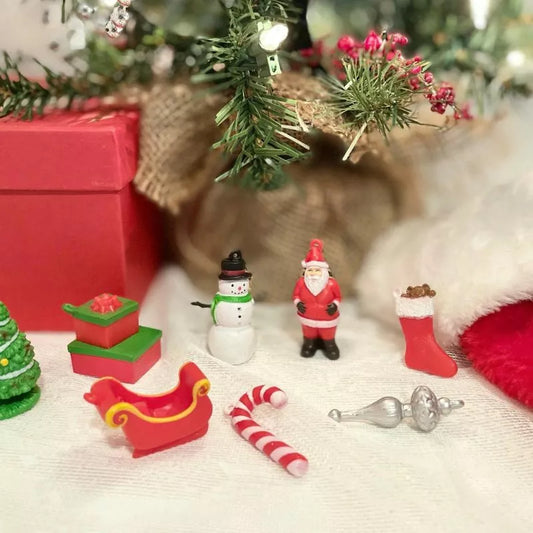 Festive TOOBS® Figurines Christmas of highly detailed miniature Santa Claus on a table next to a Christmas tree.