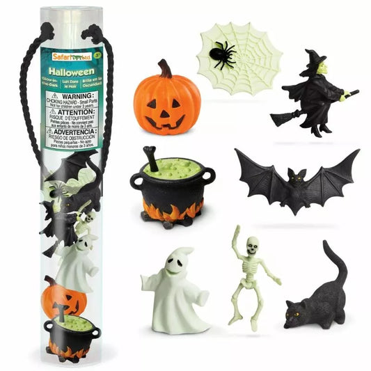 A collection of Halloween TOOBS® Figurines Glow in the Dark including a witch, bat, skeleton, ghost, black cat, spider, cauldron, and a pumpkin decoration set against a white background.