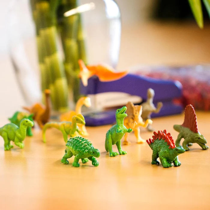 TOOBS® Figurines Dinos on a table next to a vase.