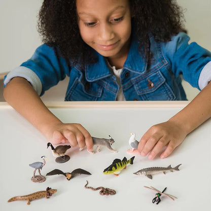 A girl is playing with a set of TOOBS® Figurines Great Lakes.