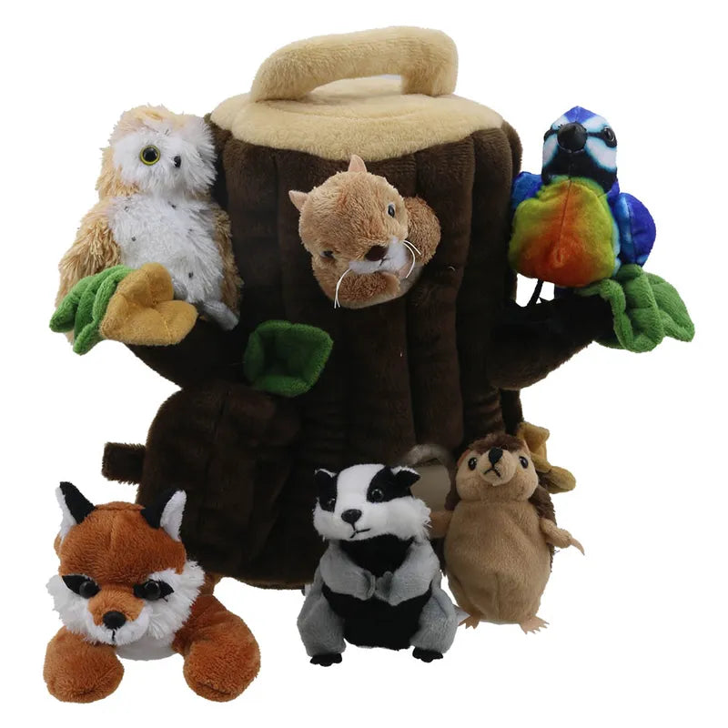 The Puppet Company Hide Away Tree House includes a plush tree trunk with handle, featuring soft woodland finger puppets: an owl, squirrel, blue bird, fox, badger, and chipmunk. These animals are positioned for interactive play in a playful forest scene.