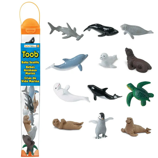 Image showing a collection of miniature TOOB® Figurines Baby Sea Life by Safari Ltd, including dolphins, sharks, seals, a turtle, and a penguin, displayed alongside their packaging.