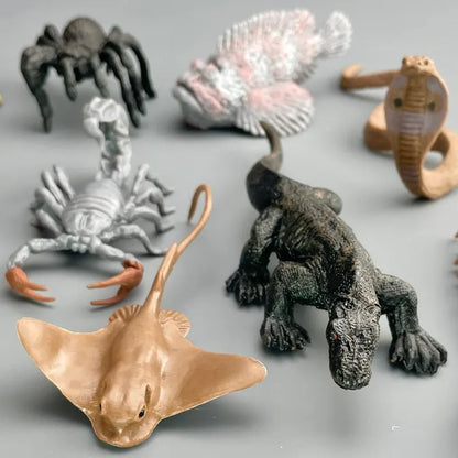 A collection of TOOB® Figurines Venomous Creatures including a stingray, dinosaur, spider, scorpion, and others on a plain background.