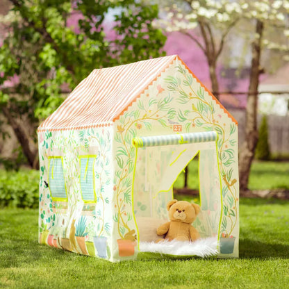 A Djeco teddy bear is sitting in a Djeco Playhouse.