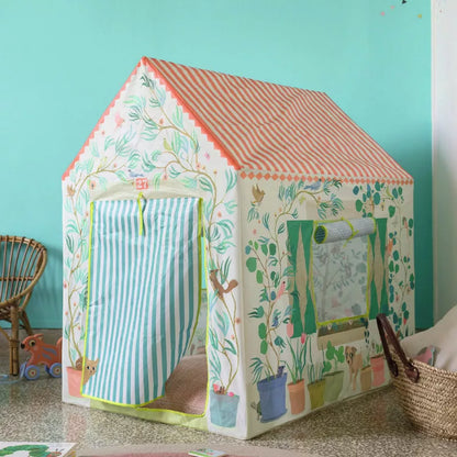 A Djeco Playhouse sitting on top of a counter next to a basket.