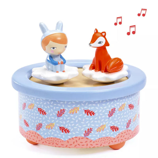 A Djeco Musical Box Fox Melody and a fox sitting on top of a blue box.