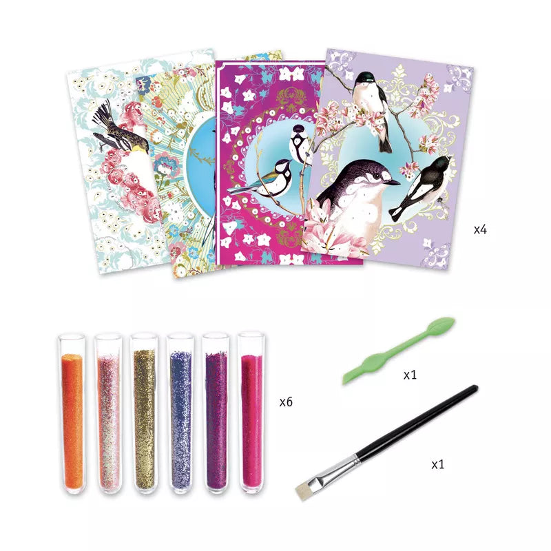 Art kit with four bird-themed cards, six tubes of colored glitter, a green dual-ended spatula, and a paintbrush, arranged on a white background.