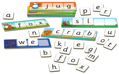 Introducing the Orchard Toys Match And Spell set, featuring word-building cards with images such as a jug, crab, fox, and spider web. Small letter tiles are included and can be used to complete words on the cards like "jug" and "fox.