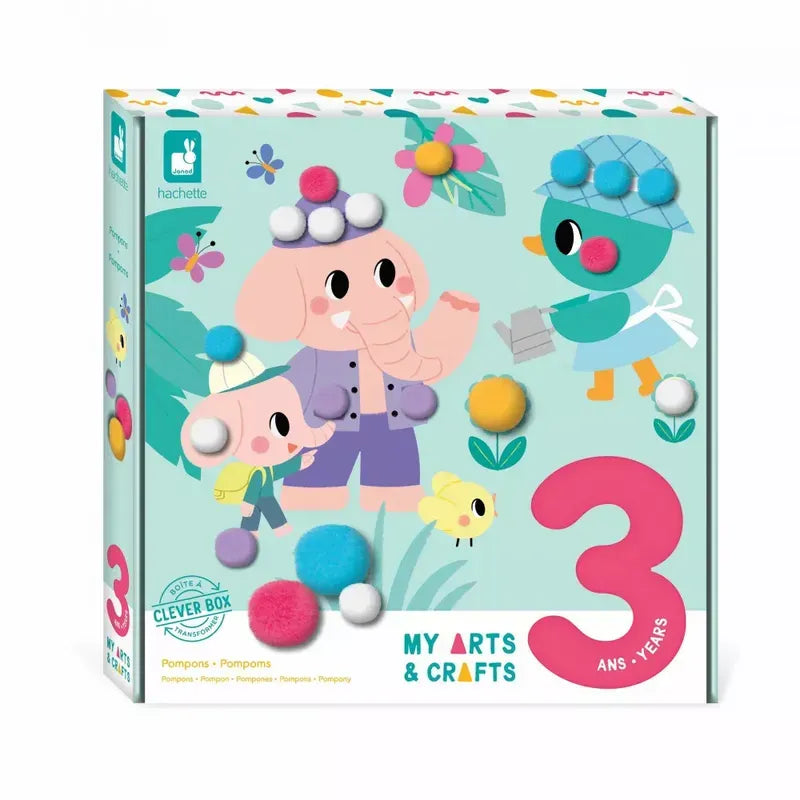 A vibrant box for a children's arts and crafts kit, featuring whimsical illustrations of an elephant and a bird wearing hats. The toy, designed for children aged 3 to 5 years, is decorated with playful pompom embellishments and includes text indicating it is suitable for ages 3 and up. The title of the kit reads "Janod 3 Years - Pompoms.