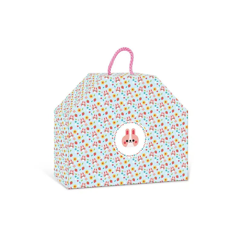 A colorful gift box with an adorable pattern of small, variously colored shapes. The box has a pink handle on top and a circular design featuring a pink bunny face in the center on the front side. Shaped like a house, it can also store the Janod 4 Pieces Of Wooden Jewellery - Flower Garden toy or even other children's jewelry kits.