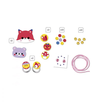 Assorted children's craft items arranged on a white background, including animal face stickers, round buttons, and rings with animal designs. There is also a bundle of pink string and small adhesive gems. This creative toy for kids is called "Janod 4 Pieces Of Wooden Jewellery To Make Pretty Forest," with quantities indicated in small white boxes next to each type of item.
