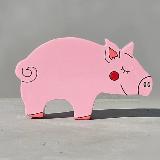 The Magnetic Wooden Pig Play Figure is sitting on a gray surface.