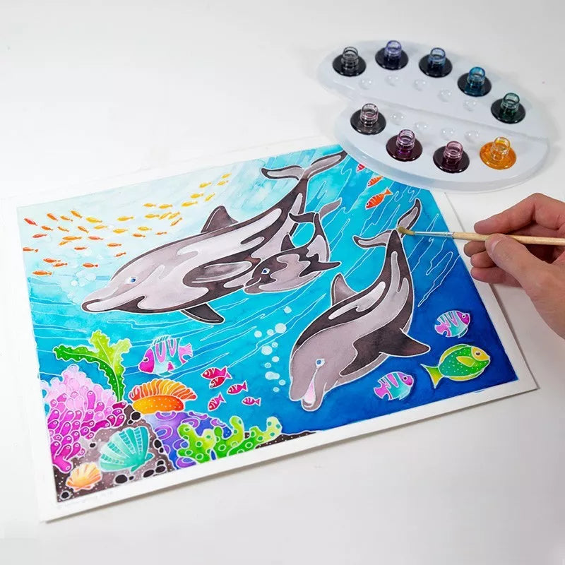 A person using the Sentosphere Aquarellum Dolphins painting kit to depict dolphins on a piece of paper.