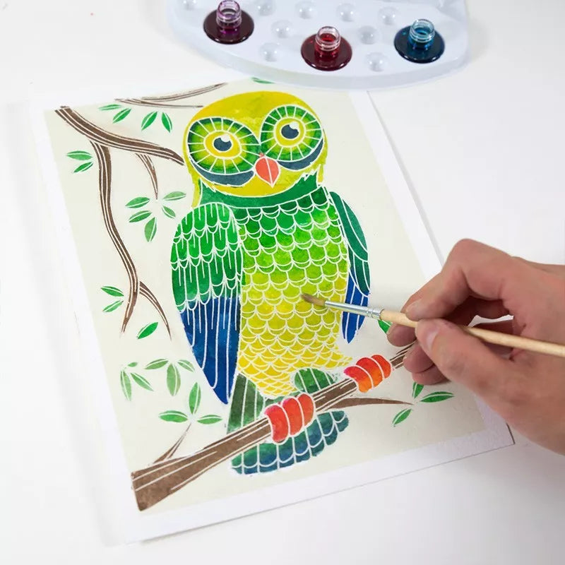 A child painting a Sentosphere Aquarellum Junior Owls on a piece of paper.