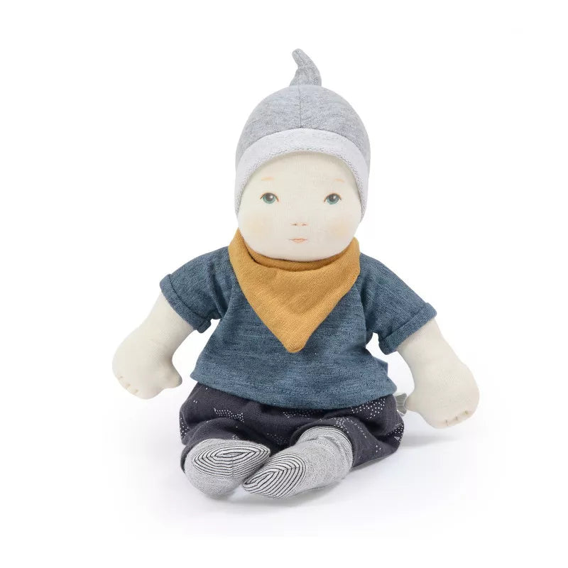a doll with a scarf and hat sitting on the ground.