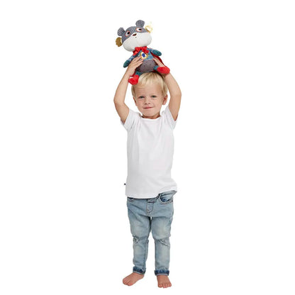 A young child with blonde hair is standing barefoot, holding a Wilberry Super Hero Bear above their head, as if engaged in imaginative play. Dressed in a white t-shirt and light blue jeans, they look ready to dive into adventure. The background is plain white.