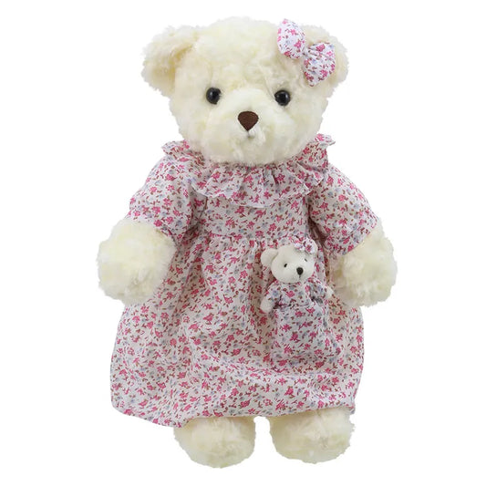 A Wilberry Dressed Animal Bedtime Bear Nightie wearing a floral dress with a matching bow on its head. The teddy is holding a smaller baby bear, also dressed in a matching floral outfit. Both bears are cream-colored and have a soft, fluffy appearance, making them the perfect birthday present.