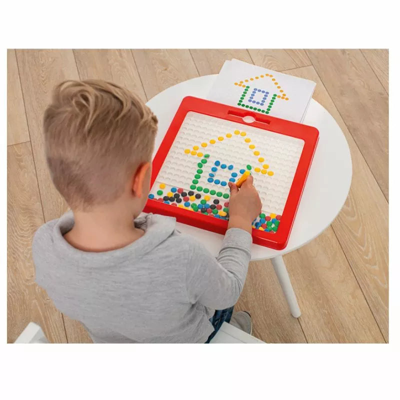 A young boy is playing with a Magnetboard "Bright Colours".