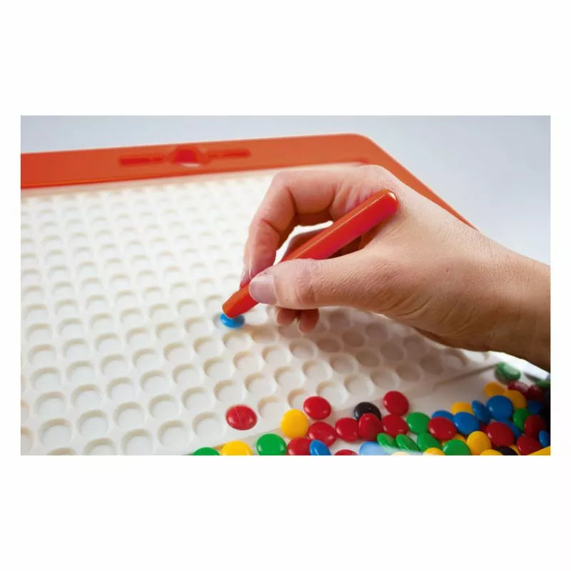 A person holding a Magnetboard "Bright Colours" over a tray of candy.
