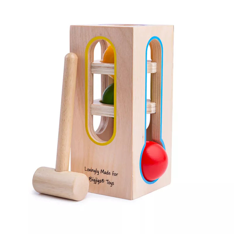 Wooden traditional toy with a movable hammer and two colored balls inside clear plastic tubes for developmental play, isolated on a white background, Bigjigs Ball Fall.