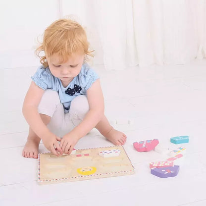 A little girl playing with a Bigjigs Dressing Girl Puzzle by Bigjigs.