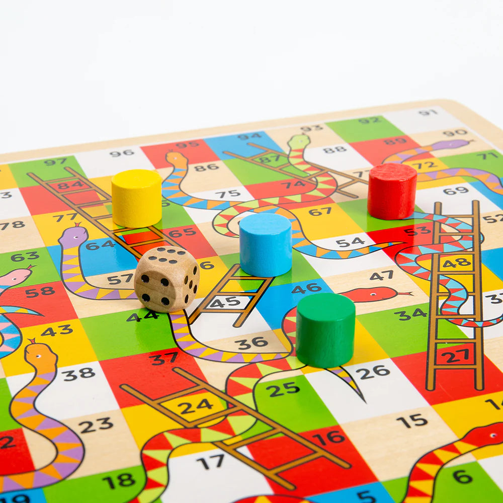 A close up of the Bigjigs Traditional Snakes & Ladders Game on a table.