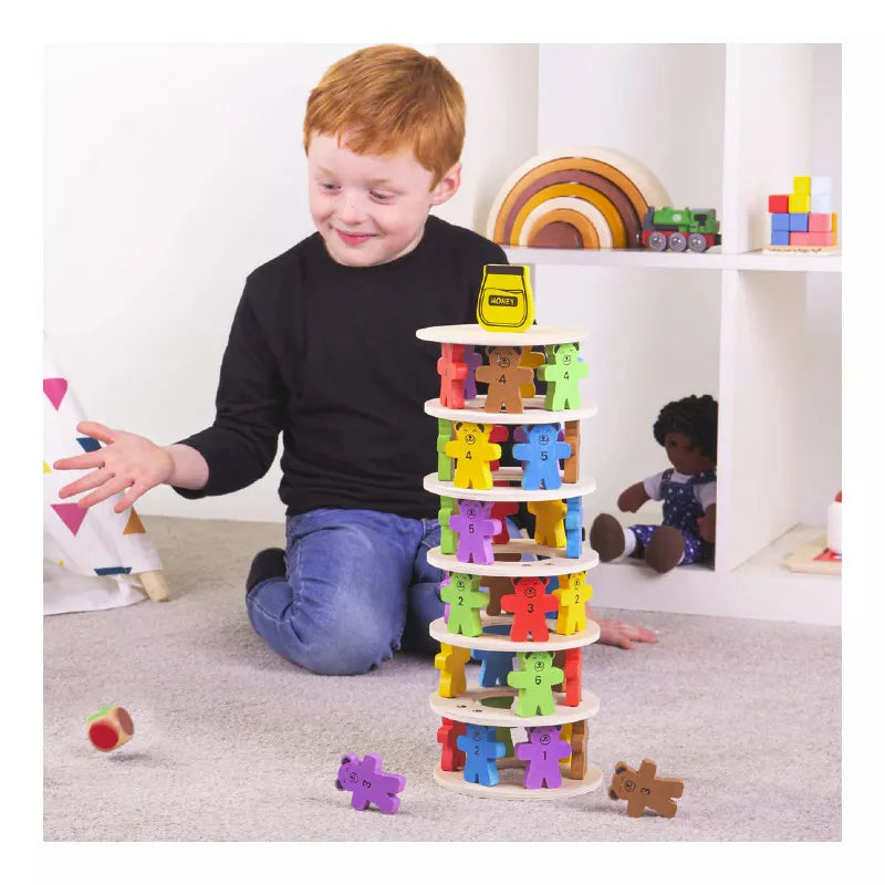 A young boy playing with a tower of Bigjigs Tumbling Teddies Balance Game.