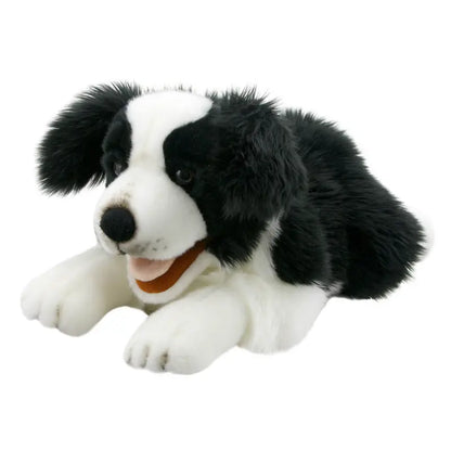 The Border Collie Hand Puppet - Playful Puppies features a black and white border collie puppy with floppy ears, lying down with its mouth open in a smile on a white background.