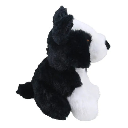 The Wilberry Eco Mini Border Collie is a black and white plush toy dog, sitting upright and facing right, made from eco-friendly recycled materials.
