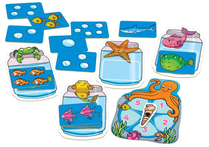 Introducing the Orchard Toys Catch & Count Game, a vibrant counting game with playful cartoon sea creatures. This set contains cards showcasing images of fish, bubbles, and a shark, in addition to jars and a spinner featuring a starfish, octopus, frog, and fish.