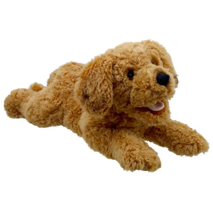 The Cockapoo Hand Puppet - Playful Puppies features a cuddly cockapoo with curly light brown fur, black eyes, and a pink tongue, lying down with front legs stretched forward and back legs extended behind.