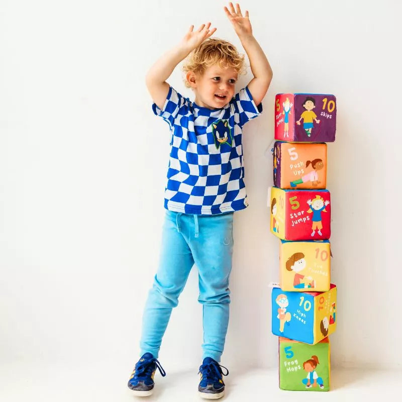 A young boy engaged in physical activity, stacking CubeFun Farm cubes.