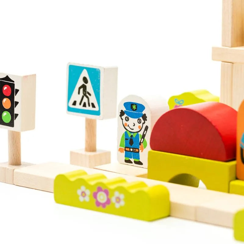 A close-up of the colorful Cubika ECO Wooden Blocks Construction City, depicting various traffic signs and figures designed for toddlers. The set, painted with safe water-based paints, includes a traffic light, pedestrian crossing sign, a police officer figure, and various other blocks in yellow, red, and green. It's perfect for imaginative play in a small town setup.