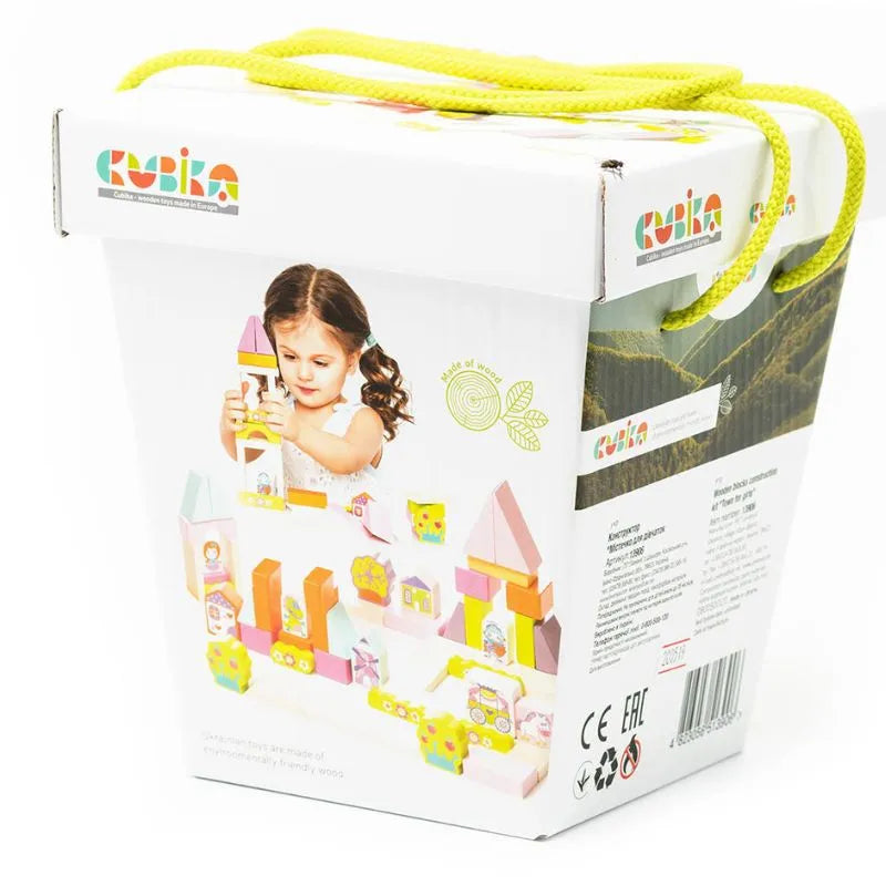 A product image of the "Cubika ECO Wooden Blocks Construction Fantasy World" toy set in a white box with a handle made of braided yellow cords. The box showcases a photo of a child engaging in imaginative play with colorful wooden blocks, the brand name "Kubika," and product information on the back. Perfect for toddlers!