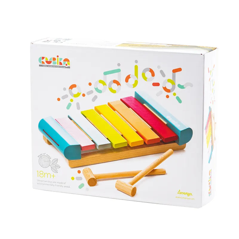 The Cubika Wooden Xylophone is a vibrant children's toy in white packaging with colorful graphics, featuring blue, red, yellow, orange, and green keys along with two wooden mallets. It's perfect for introducing toddlers to music and suitable for ages 18 months and up.