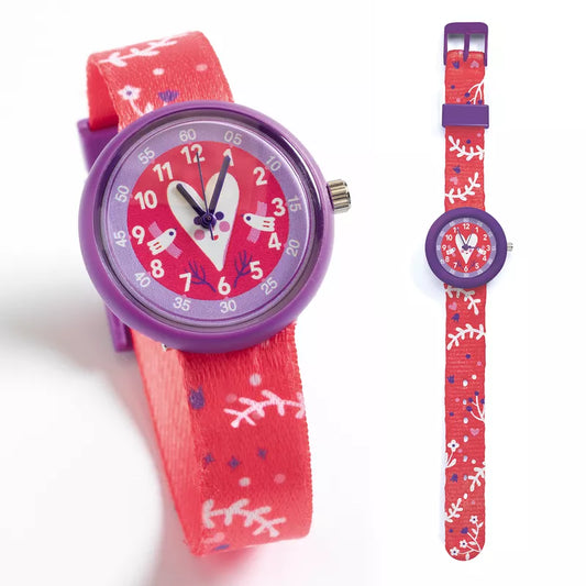 A Djeco Watch Heart and a wrist watch are shown next to each other.