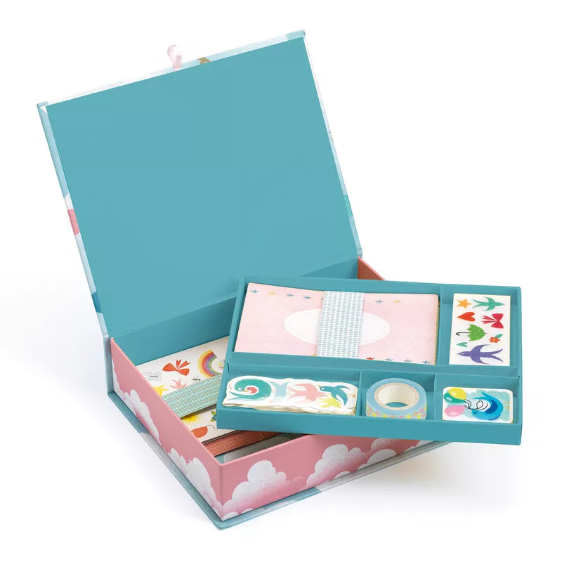 A blue and pink Djeco Correspondence Charlotte Box Set with a stationery set, including a notepad, pencils, and cute illustrations inside.