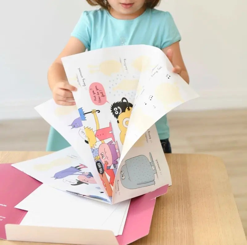 A young child stands at a table, interacting with the Poppik Discovery Sticker Poster – Emotion. The large, colorful poster features playful illustrations and cartoon animals, creating a fun and educational environment. Only the child's shoulders down are visible.