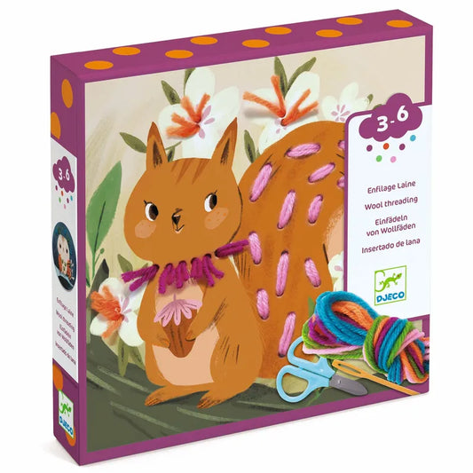 The Djeco Little Ones Introduction to threading is a colorful craft kit box with an illustrated squirrel and pastel woolen threads. It includes wool, a plastic needle, and scissors, making it the perfect embroidery toy for enhancing dexterity in children aged 3-6.