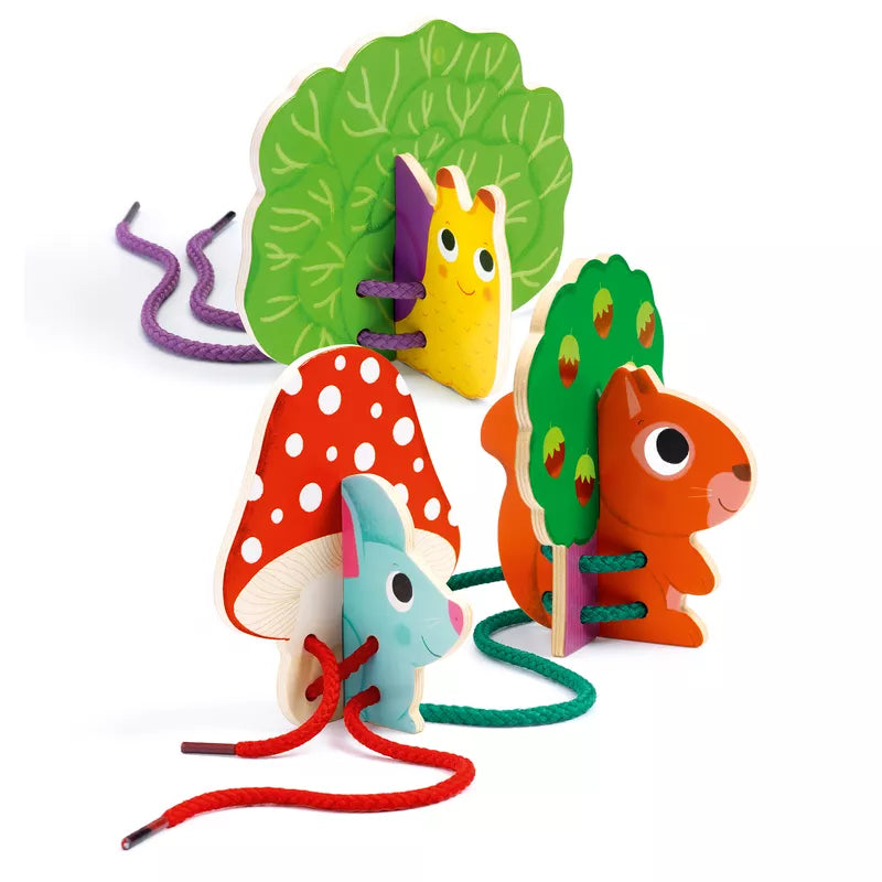 A group of Djeco Lace-up Duo wooden toys sitting on top of a white surface.