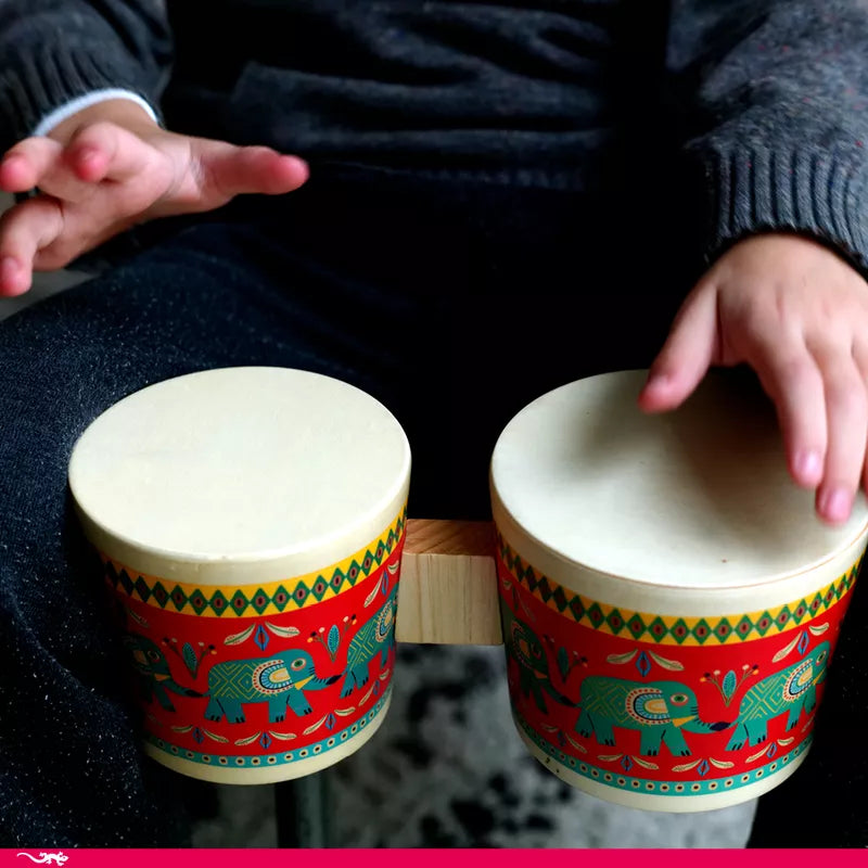 A person sitting on a chair holding two Djeco Animambo Bongo drums.